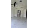 Bright and airy main bedroom featuring a ceiling fan and a door leading to the bathroom at 16475 Hillsborough Blvd, Port Charlotte, FL 33954