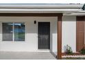 Close-up of a modern front door framed by updated windows and freshly painted trim, enhancing curb appeal at 1740 Lucas Dr, Clearwater, FL 33759