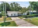 Quaint single-story home featuring mature landscaping, a paved driveway, and a welcoming facade at 1937 N Highland Ave, Clearwater, FL 33755