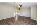 Inviting living area featuring wood-look floors, neutral walls, and access to the dining area and outdoor patio at 3460 Tomahawk Ave, Spring Hill, FL 34606