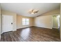 Bright living room with modern floors, a ceiling fan, and a large window offering plenty of light at 3460 Tomahawk Ave, Spring Hill, FL 34606