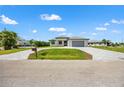 Expansive paved driveway leads to this modern single-story home with well-maintained landscaping on a bright day at 27 Bunker Ct, Rotonda West, FL 33947