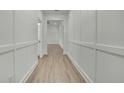 Bright hallway features hardwood floors, white walls with decorative trim, and leads to other rooms at 9739 Loretto St, Spring Hill, FL 34608