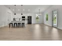 Bright living room with hardwood floors, an open floor plan, kitchen access, and lots of natural light at 9739 Loretto St, Spring Hill, FL 34608