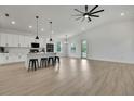 Bright living room with hardwood floors, a modern ceiling fan, an open floor plan, and kitchen access at 9739 Loretto St, Spring Hill, FL 34608