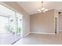 Neutral dining area with tiled floors, sliding doors to the patio, and a chandelier at 1049 Presque Isle Dr, Port Charlotte, FL 33952