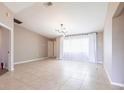 Spacious living room with tiled floors, neutral walls, and modern light fixture at 1049 Presque Isle Dr, Port Charlotte, FL 33952