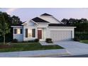 Single-story home featuring a 2 car garage, charming architectural details and neat front lawn at 12515 Shafton Rd, Spring Hill, FL 34609
