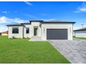 Attractive one-story home featuring a well-maintained lawn and a two-car garage in a suburban neighborhood at 3323 Elkcam Blvd, Port Charlotte, FL 33952