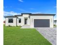 Contemporary single-Gathering home with fresh landscaping and a spacious driveway leading to an attached garage at 3323 Elkcam Blvd, Port Charlotte, FL 33952