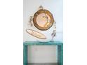 Stylish entryway table decorated with nautical theme decor and a round wood-framed mirror at 4311 123Rd W St, Cortez, FL 34215