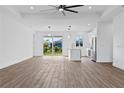 Open-concept layout with natural light and wood flooring, seamlessly connects living room to kitchen at 10071 Kingsville Dr, Port Charlotte, FL 33981