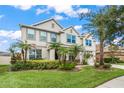 Beautiful two-story home featuring a manicured lawn, lush landscaping, and a welcoming facade at 10720 Breaking Rocks Dr, Tampa, FL 33647