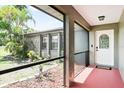 Screened-in porch features tiled flooring, neutral walls, and views of the front yard and property at 1302 Georgetowne Cir, Sarasota, FL 34232