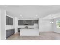 Spacious kitchen with gray cabinets, a white island, stainless appliances, and ample counter space for cooking at 9581 Vibrant Lane, Venice, FL 34292