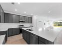 Contemporary kitchen with gray cabinetry, a large island, stainless steel appliances, and an open layout at 9596 Vibrant Lane, Venice, FL 34292