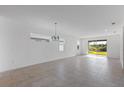 Spacious living room featuring tile floors, recessed lighting, and large sliding glass doors leading to the outside at 9596 Vibrant Lane, Venice, FL 34292
