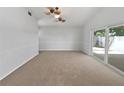 Spacious living room featuring carpet flooring, neutral paint, and a sliding door at 10344 Rosemount Dr, Tampa, FL 33624
