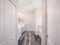 Hallway view of bathroom with dual vanity, tub, and tiled shower at 11126 Jenny Wren Rd, Weeki Wachee, FL 34614