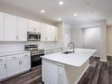 Modern kitchen featuring white cabinets, stainless steel appliances, and a spacious island at 11126 Jenny Wren Rd, Weeki Wachee, FL 34614