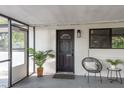 Cozy screened front porch with a decorative door and comfortable seating space at 709 1St Ne Ave, Largo, FL 33770