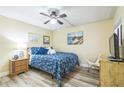Bedroom with updated flooring, ceiling fan, and coastal artwork at 3805 E Bay Dr # 204, Holmes Beach, FL 34217