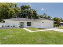 Charming home featuring a minimalist design, a wide driveway, and a well-manicured lawn at 3920 Basswood Dr, Sarasota, FL 34232