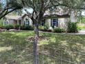 Beautiful single-story home with a spacious lawn and mature trees, complemented by charming landscaping and an American flag at 10533 Hazel St, Largo, FL 33778