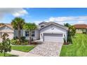 Attractive single-story home featuring a paved driveway, tropical landscaping, and an attached two-car garage at 15503 Corona Del Mar Dr, Wimauma, FL 33598