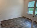 Bright bedroom with wood floors and a large window offering natural light at 3441 Gramercy Ln, Spring Hill, FL 34609