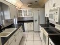 Functional kitchen with white cabinets, black countertops, and modern appliances at 4650 Orlando Cir, Bradenton, FL 34207