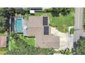 Aerial shot of a home with a screened-in pool, solar panels, and a well-maintained driveway and yard at 2531 Lake Ellen Dr, Tampa, FL 33618