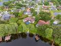 Aerial view of property showcasing pool, lake access, boat dock, and well-maintained surrounding neighborhood at 15007 Laurel Cove Cir, Odessa, FL 33556