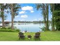 Picturesque backyard view with lake access, chairs, and a jet ski, perfect for enjoying waterfront living at 15007 Laurel Cove Cir, Odessa, FL 33556