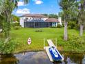 Spacious backyard with screened pool, kayak, jet ski, and waterfront access, ideal for outdoor recreation at 15007 Laurel Cove Cir, Odessa, FL 33556