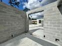 View through block walls and doorway of the concrete slab foundation for new home construction at 18141 Spartonvail Ave, Port Charlotte, FL 33954