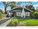 Inviting single-Gathering home featuring a landscaped front yard, a white brick chimney, and beautiful architectural details at 132 17Th N Ave, St Petersburg, FL 33704
