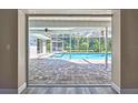 Screened-in pool area boasts brick-paved patio, ceiling fan, and lush landscaping for a private backyard oasis at 13295 Don Loop, Spring Hill, FL 34609
