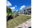Manicured front yard with lush green grass and tropical landscaping at 15301 Chinook Way, Port Charlotte, FL 33981