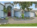 Stylish front entrance showcasing a blue exterior, a manicured landscape bed, and a well-maintained yard at 28707 Raleigh Pl, Wesley Chapel, FL 33545