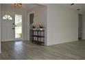 Bright foyer showcasing updated flooring, a modern display table, and a glimpse into the kitchen at 9093 108Th St, Seminole, FL 33772