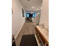Bright hallway with wood-look floors leads to the living area and staircase at 10302 Lavender Aster Trl, San Antonio, FL 33576