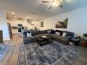 Spacious living room open to the kitchen featuring a large sectional and stylish decor at 10302 Lavender Aster Trl, San Antonio, FL 33576