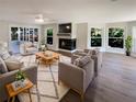 Bright and airy living room showcasing hardwood floors, a fireplace, and abundant natural light at 5511 Drinkard Dr, New Port Richey, FL 34653