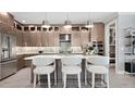 Contemporary kitchen with modern appliances, stylish pendant lights, an island with seating, and sleek cabinetry at 14375 Hammock Oak St, Parrish, FL 34219