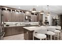 Stylish kitchen features sleek cabinets, stainless steel appliances, island with seating, and designer lighting fixtures at 14375 Hammock Oak St, Parrish, FL 34219