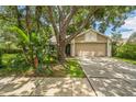 Charming home featuring a two-car garage, neutral color scheme, and mature trees providing ample shade at 2002 Culpepper Dr, Brandon, FL 33511