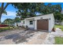 Charming home featuring a well-manicured lawn, gravel walkway, and one car garage at 6208 S Harold Ave, Tampa, FL 33616