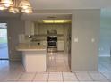 Open-concept kitchen with stainless steel appliances and tile flooring at 7240 Rosarian Dr, Port Richey, FL 34668