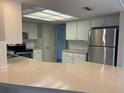 Bright kitchen with stainless steel appliances, white cabinets, and spacious breakfast bar at 7240 Rosarian Dr, Port Richey, FL 34668